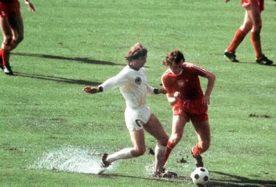 Bad playing conditions - Polish defender Antoni Szymanowski (r) tries to stop German striker Gerd Hölzenbein (l) in a puddle 