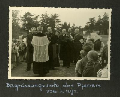 Begrüßung durch den Pfarrer aus Lage - Begrüßung durch den Pfarrer aus Lage, schwarz-weiß Fotografie, 1955, 8,5 x 13,5 cm 