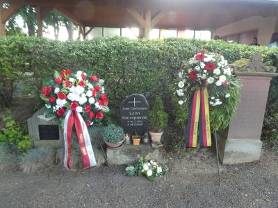 Der Gedenkstein an der Gedenkveranstaltung für Leon Szczepaniak am 25. Mai 2022 mit den Kränzen des Polnischen Generalkonsulats und der Ortsgemeinde Stadecken-Elsheim, 2022