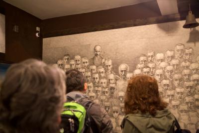 Teilnehmende der Studienreise in der Ausstellung von Marian Kołodziej - Teilnehmende der Studienreise rezipieren die gezeichneten Porträts mit den verzerrten, hageren Gesichtszüge der KZ-Insassen in der Ausstellung von Marian Kołodziej, Oświęcim 2019. 