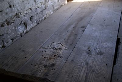 Schnitzerei der inhaftierten Menschen - Schnitzereien oder Malereien der inhaftierten Menschen finden sich auch in den Holzwänden und Bettgestellen der Wohnbaracken in Auschwitz II, Oświęcim 2019. 