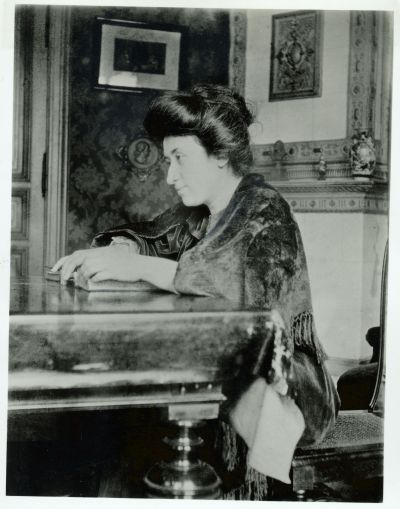 Rosa Luxemburg mit einem Buch an einem Tisch, Berlin 1907