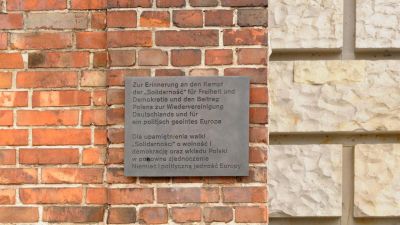 Die Tafel wurde an einem Stück Mauer der Danziger Werft angebracht und erinnert an den Beitrag Polens zur Wiedervereinigung Deutschlands und zur Einheit Europas.